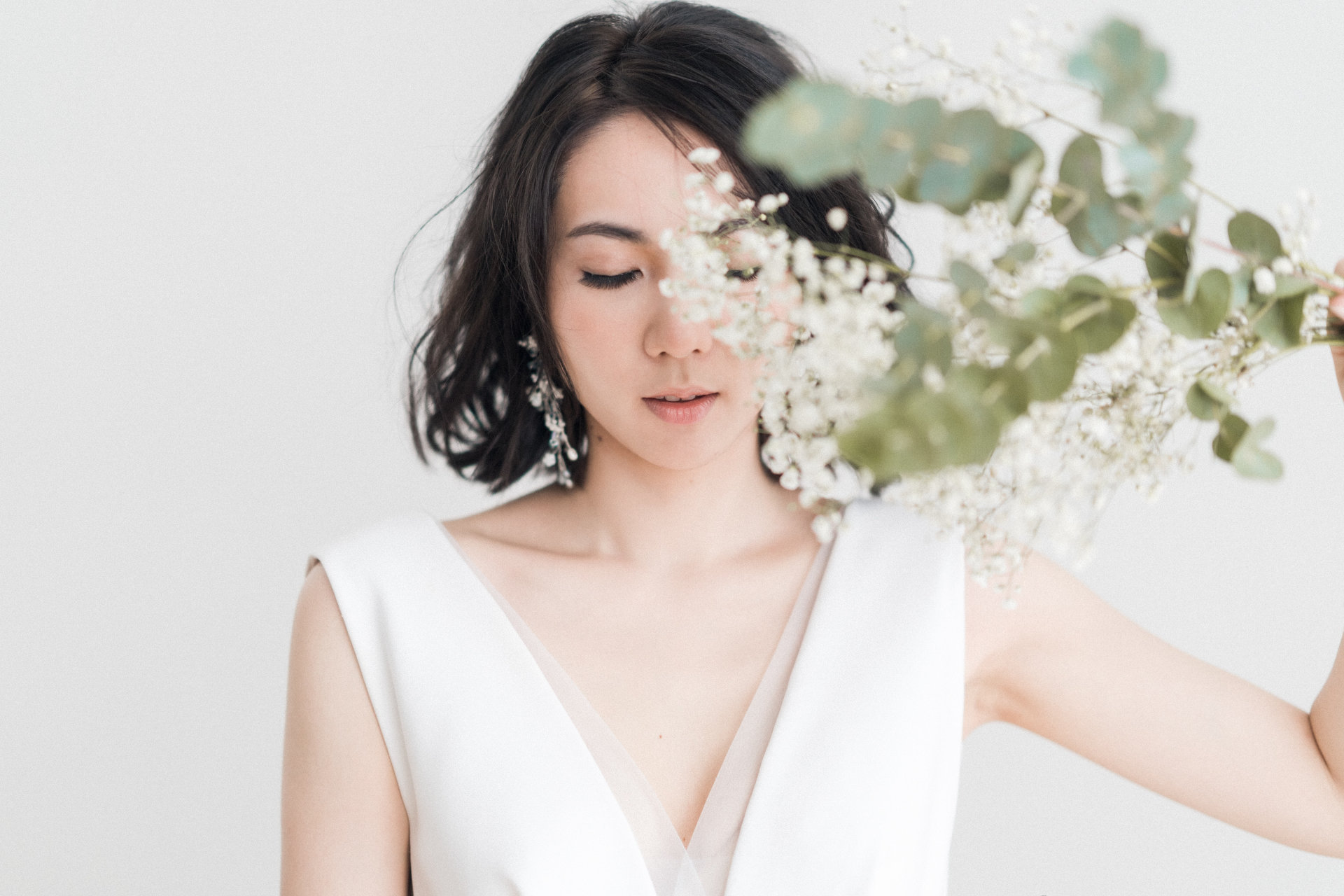 Woman in white sleeveless top with white flower