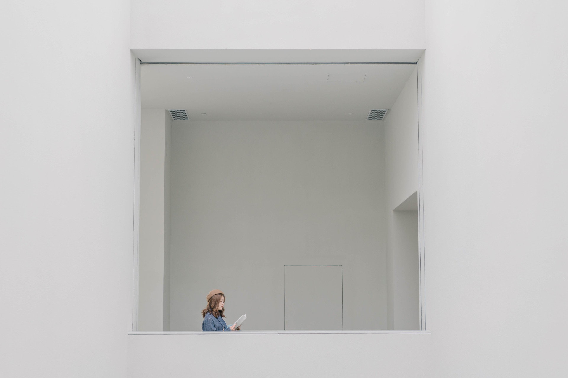 A woman in a blue shirt is reading a book