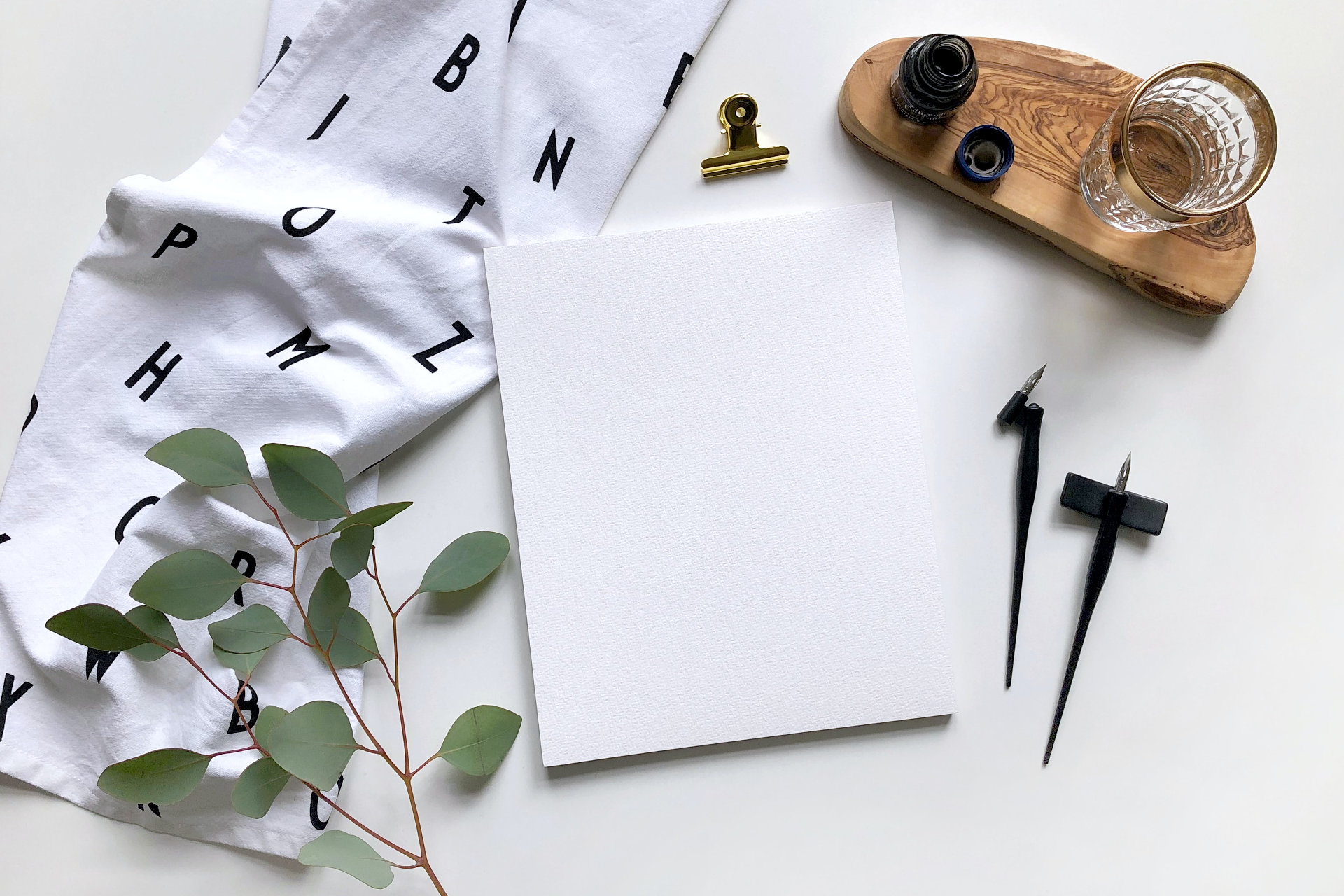 Topview mockup calligraphy with eucalyptus, ink and nibs